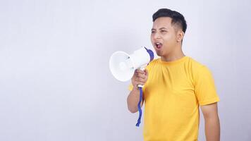 Portrait of Asian young man shouting on megaphone isolated on white background photo