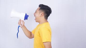 Side view of Asian man shouting madly on megaphone isolated on white background photo