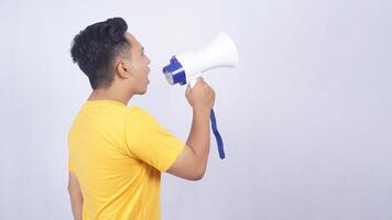 Side view portrait of Asian man shouting on megaphone isolated on white background photo