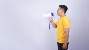 Side view of Asian young man shouting on megaphone isolated on white background photo