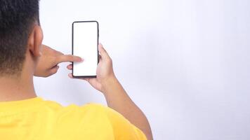 Rear view of man scrolling through blank screen mobile phone mock up isolated on white background photo