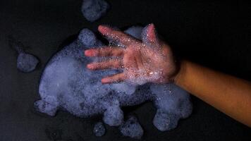 Man hand with bubbles foam isolated on black background photo