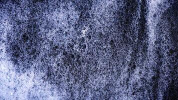 Texture of white bubbles foam isolated on black background photo