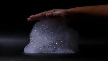 Close up of bubbles foam in hands on black background photo