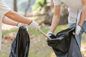 Volunteers collecting trash during a park cleanup, highlighting the importance of community involvement in environmental efforts. photo