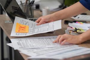 Tax Document Management. Individual organizing tax documents while preparing for filing and calculations. photo