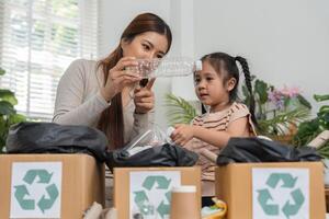Recycling and Learning. A mother and daughter collaborate to recycle plastic containers at home. photo
