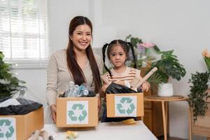 Eco-Friendly Practices and Family Togetherness. A mother smiling with her daughter while sorting recyclable materials into labeled boxes. photo