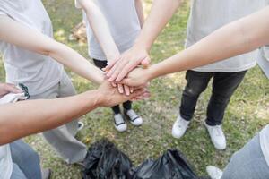 Teamwork in Action. Volunteers joining hands to symbolize unity in a clean-up project. photo