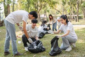 Group of young volunteers collaborating during a park cleanup, fostering community spirit and environmental responsibility. photo