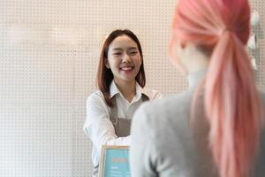Customer Interaction and Coffee Experience. A smiling barista welcoming a customer with a friendly demeanor. photo