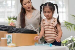 Recycling and Playful Learning. A child excitedly participates in sorting recyclable materials with her mother. photo
