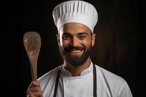 A man with a beard and a chef hat holding a wooden spoon photo