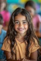 A young girl smiles while sitting in front of other children photo