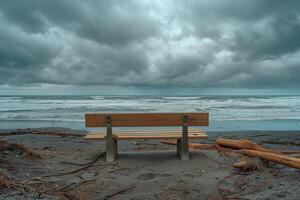 A bench sitting on a beach under a stormy sky photo