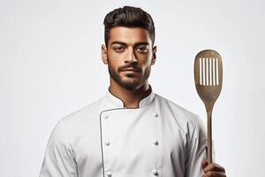 A man in a chef's uniform holding a spatula photo