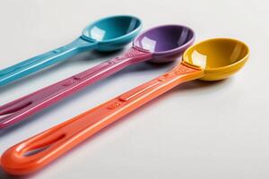 Three colorful spoons are shown on a white surface photo