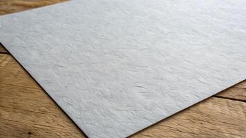 Textured gray paper sheet on rustic wooden table for creative designers and artists looking for high-quality backgrounds and textures to enhance their projects with a natural, vintage feel. photo