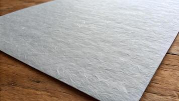 Smooth gray paper sheet on wooden surface for creative designers and craft enthusiasts looking for high-quality materials to enhance their projects with a natural, rustic feel. photo