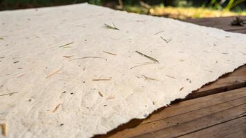 Handmade paper with natural fibers on wooden surface for eco-friendly design projects. This image showcases a rustic, organic texture perfect for sustainable art and craft enthusiasts. photo