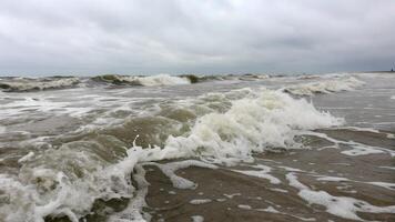Ocean waves crashing powerfully on sandy beach for nature enthusiasts and photographers photo