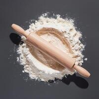 A rolling pin and flour on a gray background photo