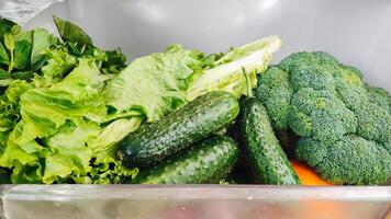 The vegetables are in the refrigerator drawer. Open the refrigerator. Healthy eating. photo
