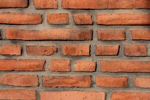 Rustic red brick wall showcasing unique texture and patterns in natural light photo