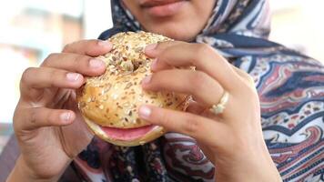 Enjoying a sesame bagel with toppings in a cozy cafe setting video