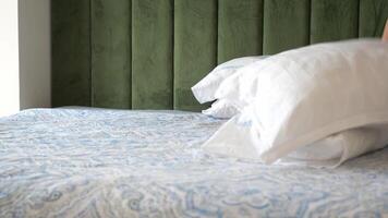 Making a bed with soft pillows and a patterned blanket in a cozy room video
