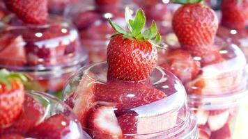 Fresh fruit cups with strawberries in a bright market setting video