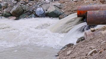 mountain river water flowing through steel pipes under temporary video