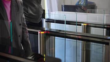 Passing through a turnstile into an office building. Office workers enter and exit through a modern turnstile, using a key card to enter. video