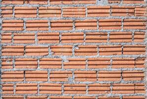 Full frame shot of brick wall. Bricks are made from clay or concrete and are widely used in house building. photo