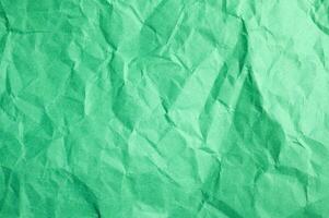 Full frame shot of crumpled green paper sheet texture and background. photo