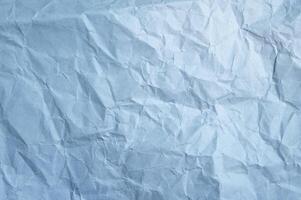 Full frame shot of crumpled light blue paper sheet texture and background. photo