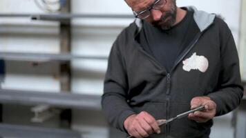 Conceptual slow motion footage about metal work, blacksmith is taking measurements of a metal bar with the use of caliper. video