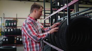 Man taking a winter tire from shelf and calling a seller video
