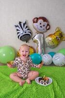 Child first birthday party with balloons in the form of African animals and a cake with a tiger photo