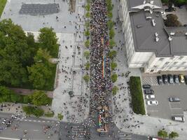 Aerial view of a large crowd marching in a city street during a public demonstration. Protest and social movement concept photo