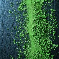 Moringa powder spread across a dark surface highlighting its texture photo
