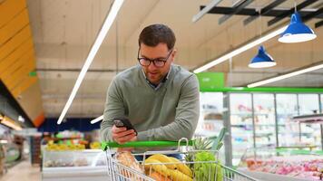 Man checking grocery list on phone while shopping video