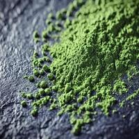 Moringa powder scattered on a dark surface showcasing vibrant color photo