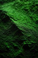 Bright green moringa powder spread across a textured surface photo