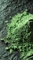 Moringa powder piled on a textured black surface photo