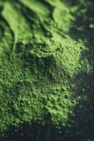 Moringa powder showcasing vibrant green color on dark surface photo