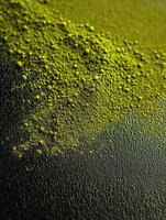 Moringa powder spread on a textured black surface photo