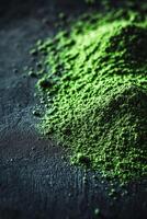 Moringa powder in vibrant green color on a dark surface photo