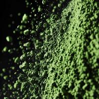 Moringa powder in fine texture captured against dark background photo