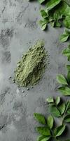Moringa powder surrounded by fresh moringa leaves on a stone surface photo
